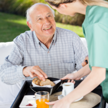 Serving foods to an elderly man.